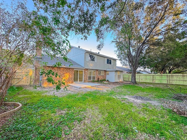 back of property featuring a lawn and a patio