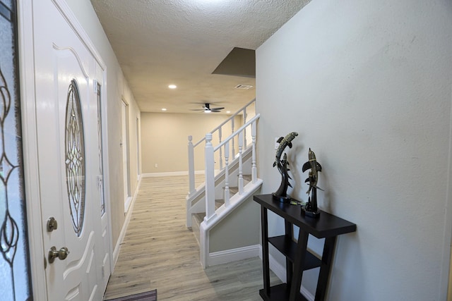 entryway featuring a textured ceiling, light hardwood / wood-style floors, and ceiling fan