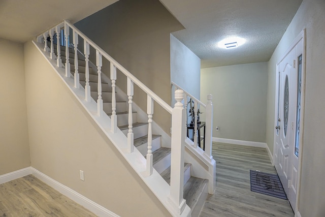 foyer entrance with hardwood / wood-style floors and a textured ceiling