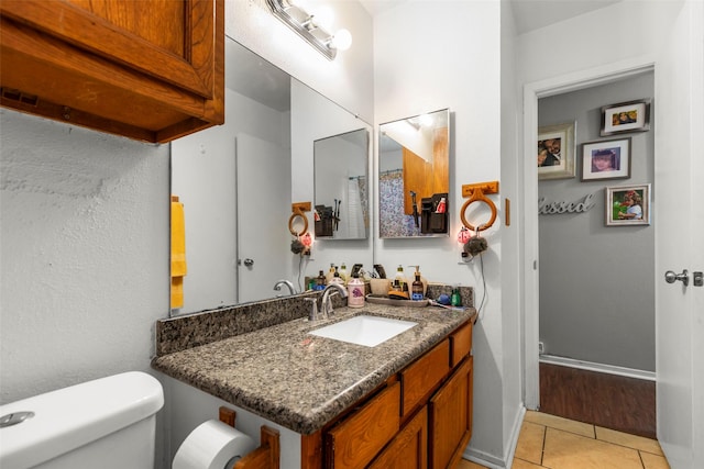 bathroom featuring tile patterned floors, vanity, and toilet