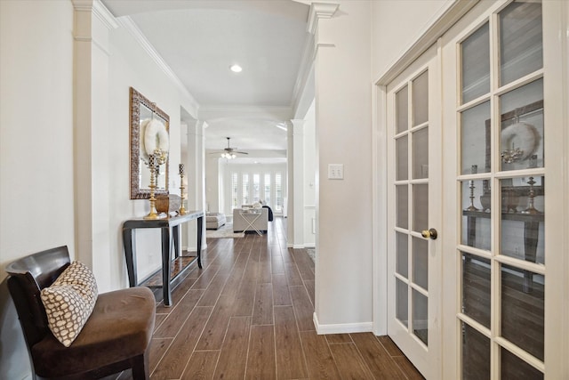 hallway featuring french doors, ornate columns, and crown molding