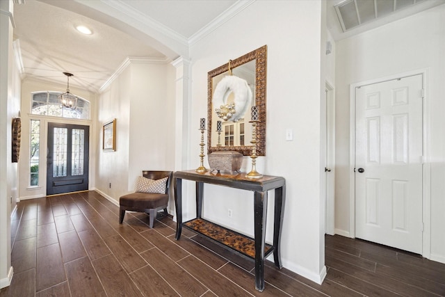 foyer featuring crown molding, vaulted ceiling, and an inviting chandelier