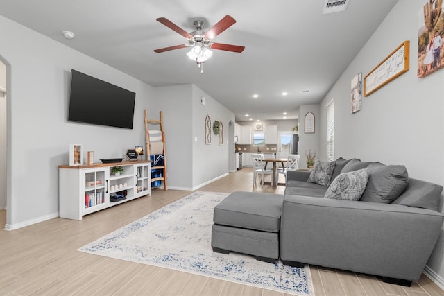 living room featuring ceiling fan and light hardwood / wood-style flooring