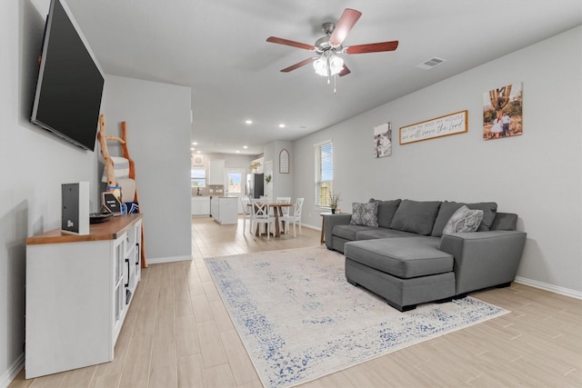 living room with ceiling fan and light hardwood / wood-style floors