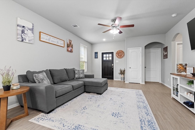 living room featuring light hardwood / wood-style flooring and ceiling fan