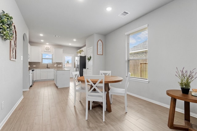 dining room with a wealth of natural light and light hardwood / wood-style flooring