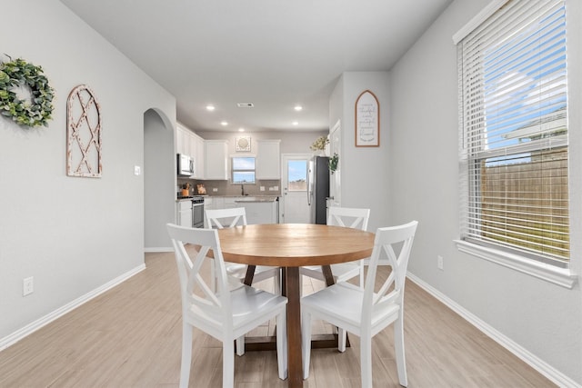 dining space featuring light hardwood / wood-style flooring and sink