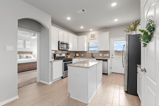 kitchen with white cabinets, sink, a kitchen island, and stainless steel appliances