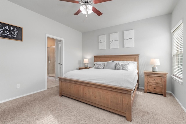 bedroom with ceiling fan, light carpet, and connected bathroom