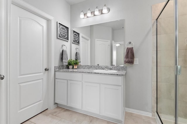 bathroom with tile patterned flooring, vanity, and walk in shower