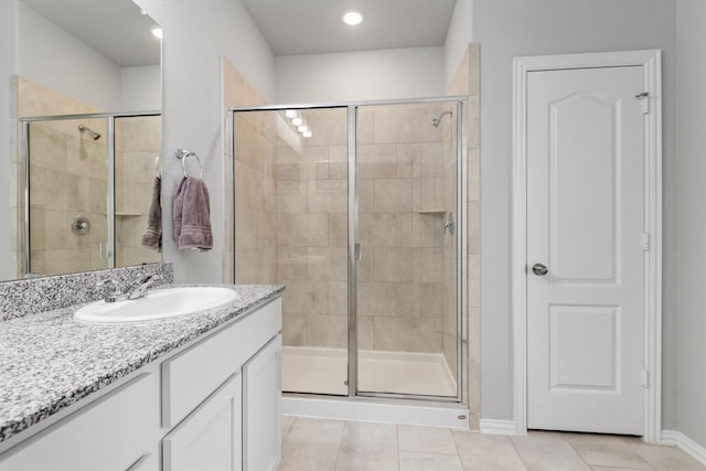 bathroom with tile patterned floors, vanity, and a shower with shower door