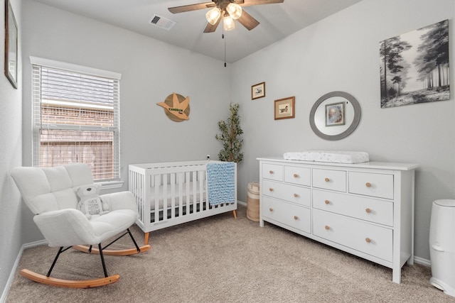 bedroom with ceiling fan, a nursery area, and light carpet