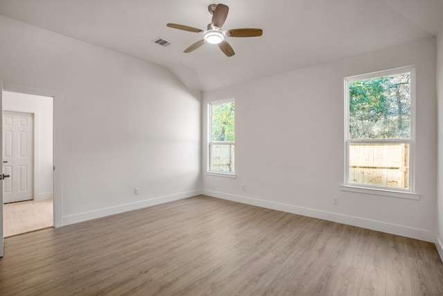 spare room with ceiling fan, light wood-type flooring, and vaulted ceiling