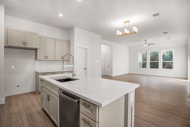 kitchen with gray cabinetry, dishwasher, sink, dark hardwood / wood-style floors, and a kitchen island with sink