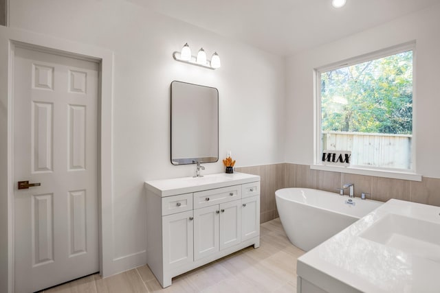 bathroom featuring vanity and a bath