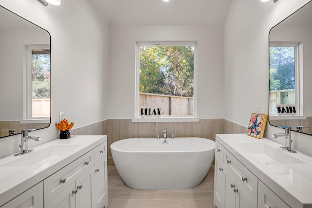 bathroom with vanity, a bathtub, and a wealth of natural light