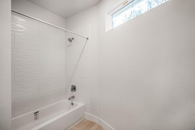 bathroom featuring tiled shower / bath combo and wood-type flooring