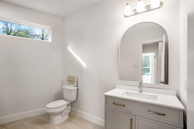 bathroom featuring tile patterned floors, a wealth of natural light, vanity, and toilet