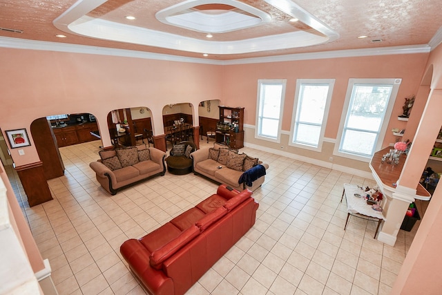 living room with crown molding, light tile patterned floors, and a tray ceiling