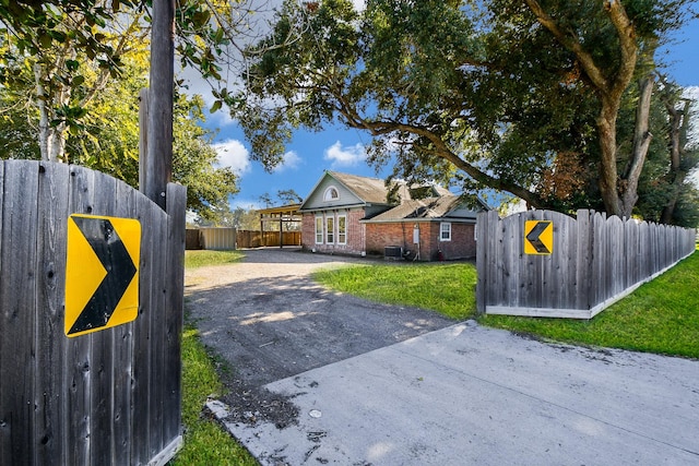 ranch-style home with a front lawn and central air condition unit