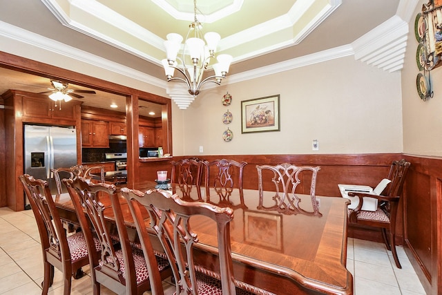 dining room with light tile patterned floors, ceiling fan with notable chandelier, ornamental molding, and a raised ceiling