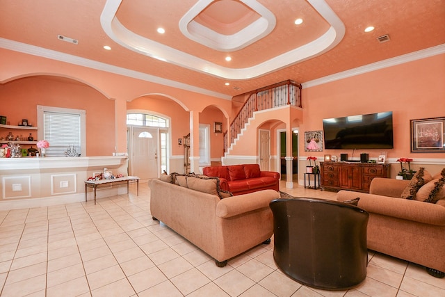 tiled living room with a raised ceiling and ornamental molding