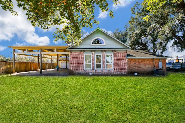 rear view of house featuring a carport, a yard, and cooling unit