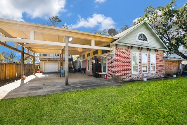 exterior space with a garage, a yard, and a patio area