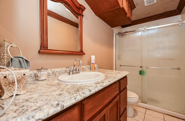 bathroom featuring tile patterned flooring, vanity, toilet, and a shower with shower door