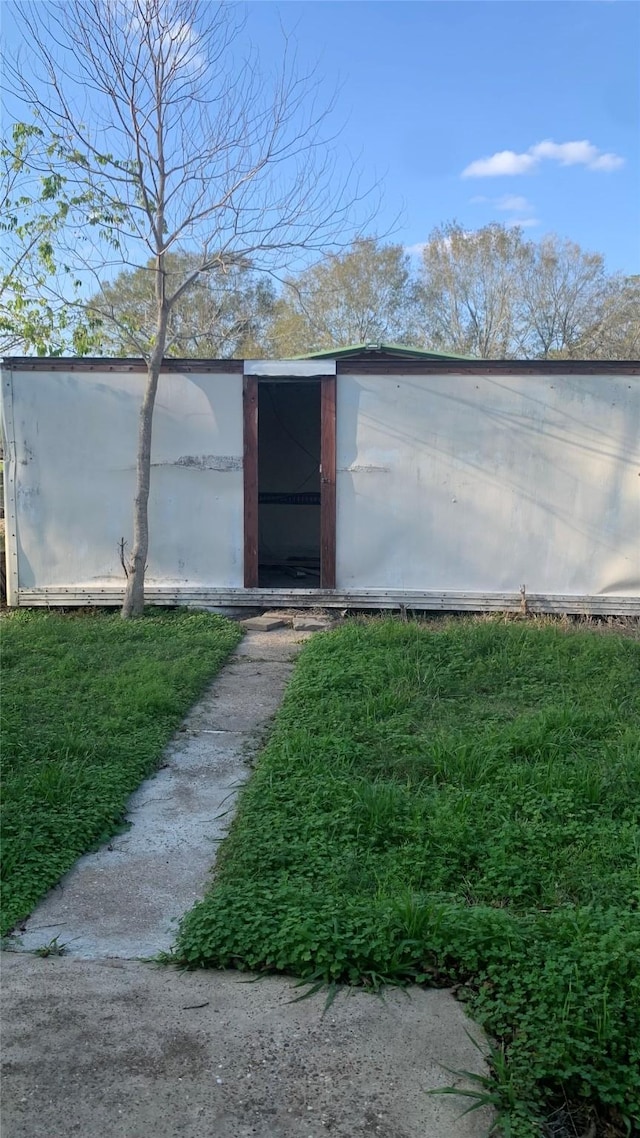 view of outdoor structure featuring a lawn