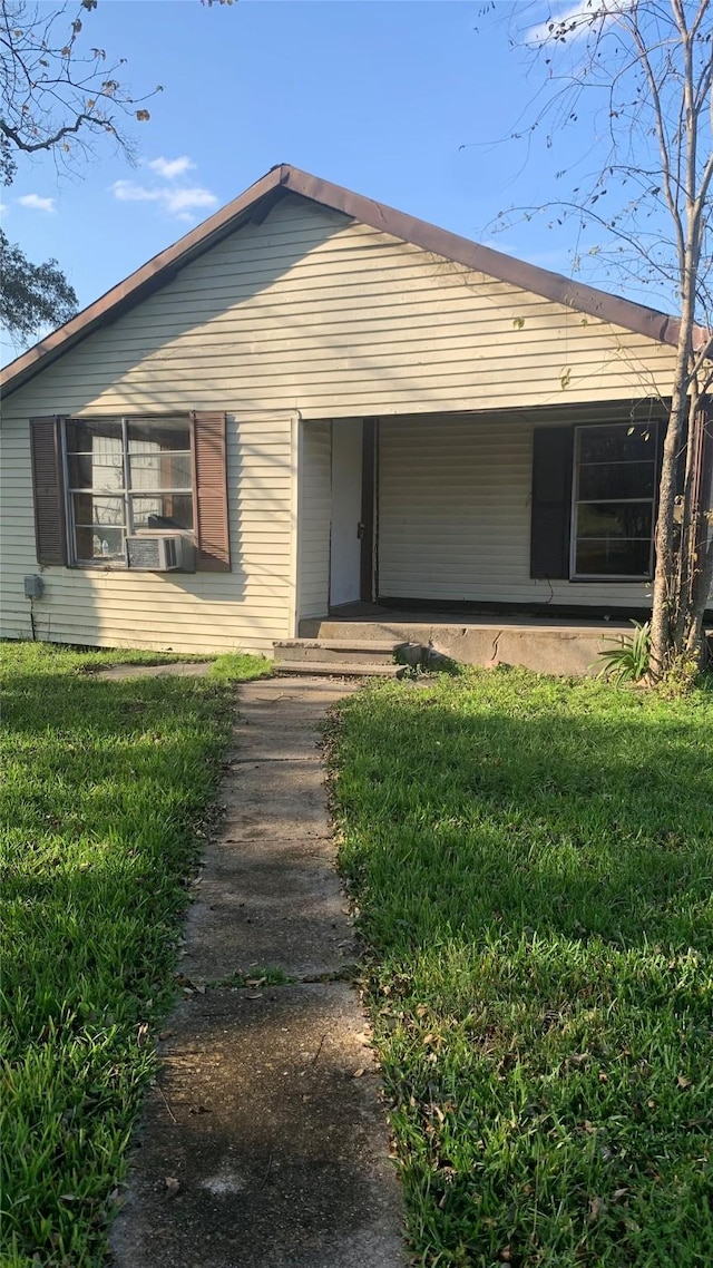 back of house featuring covered porch and a yard