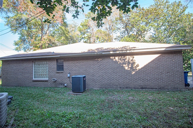 view of property exterior with central AC and a yard