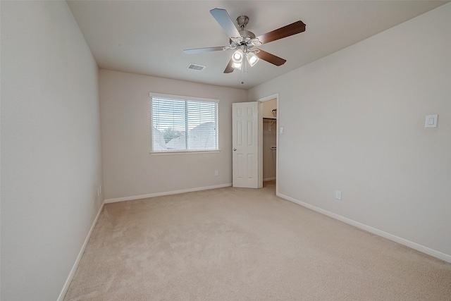 carpeted spare room with ceiling fan