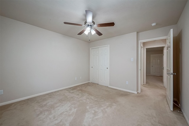 unfurnished bedroom featuring ceiling fan, a closet, and light carpet