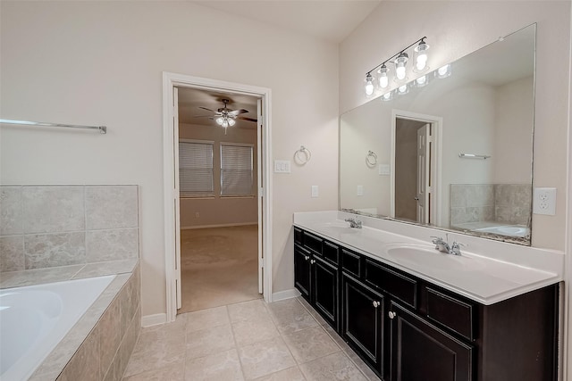 bathroom featuring tile patterned flooring, vanity, ceiling fan, and tiled tub