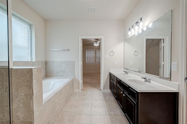 bathroom featuring tile patterned flooring, vanity, a relaxing tiled tub, and ceiling fan