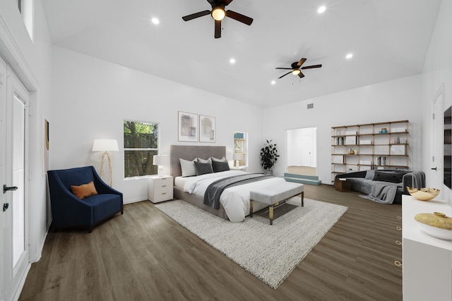 bedroom featuring ceiling fan, dark hardwood / wood-style floors, and a high ceiling