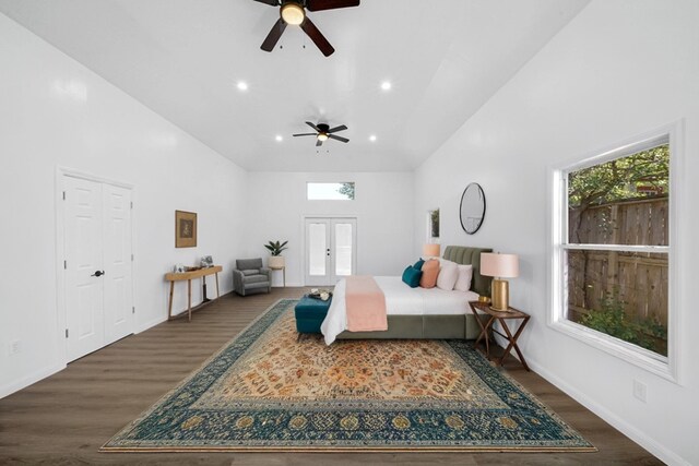 bedroom featuring ceiling fan, french doors, dark wood-type flooring, and a towering ceiling