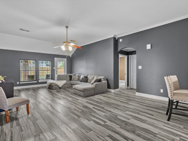 living room featuring crown molding, ceiling fan, light hardwood / wood-style floors, and vaulted ceiling