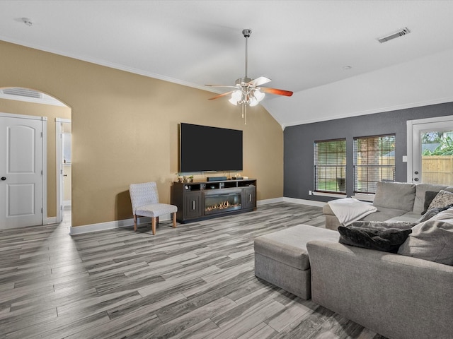 living room featuring hardwood / wood-style flooring, ceiling fan, lofted ceiling, and crown molding