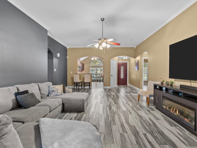 living room with light wood-type flooring, plenty of natural light, and ornamental molding