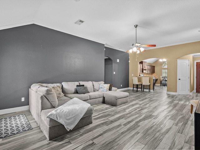 living room with lofted ceiling, hardwood / wood-style flooring, ceiling fan, and ornamental molding