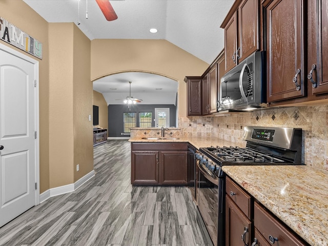 kitchen featuring dark brown cabinetry, sink, vaulted ceiling, appliances with stainless steel finishes, and light wood-type flooring