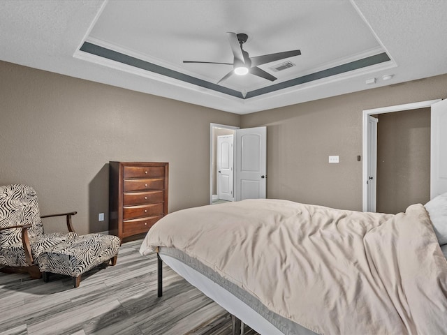 bedroom with a raised ceiling, ceiling fan, and crown molding