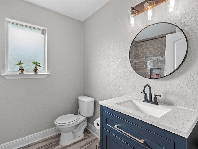 bathroom featuring wood-type flooring, vanity, toilet, and walk in shower