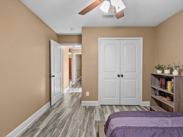 bedroom featuring ceiling fan, a closet, and light hardwood / wood-style flooring