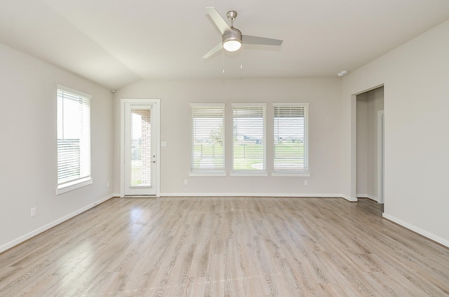 spare room featuring ceiling fan, lofted ceiling, and light wood-type flooring