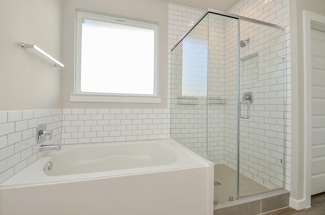 bathroom featuring shower with separate bathtub