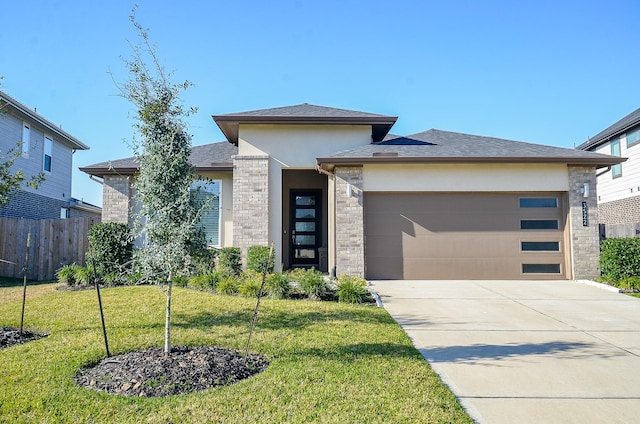 prairie-style home with a front yard and a garage