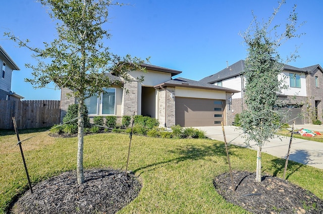 prairie-style home featuring a garage and a front lawn